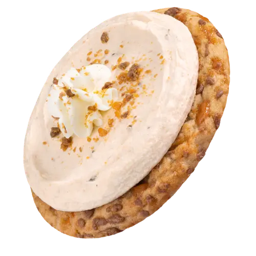A chilled peanut butter cookie rolled in Butterfinger® pieces and topped with peanut butter buttercream studded with more Butterfinger®, whipped cream, and a final Butterfinger® crunch. Butterfinger® is a trademark of Ferrero Group.